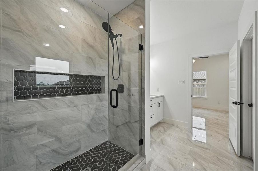 Full bathroom with a shower stall, vanity, and marble finish flooring