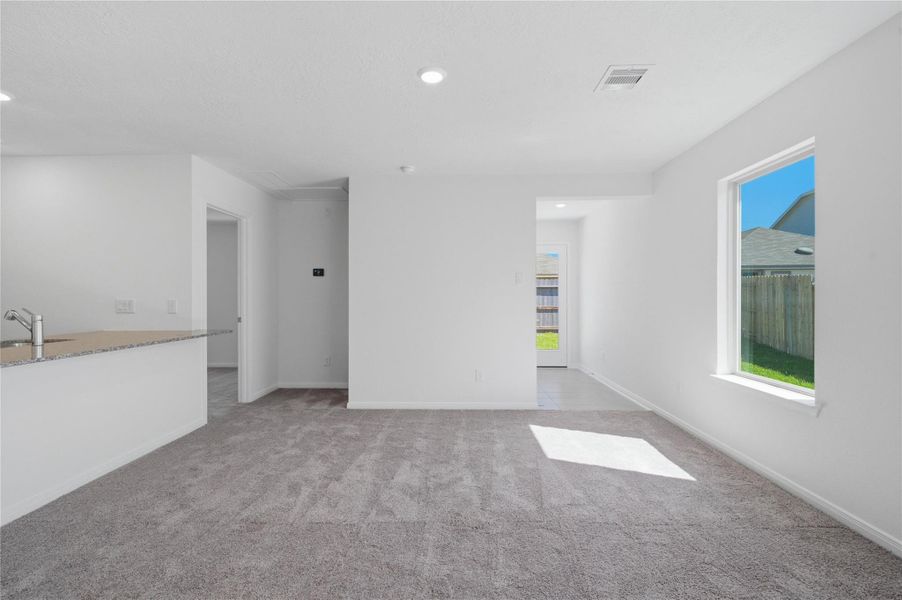 Relax and unwind after a long day in the primary suite! This generously sized room offers plush carpeting, custom neutral paint, high ceilings, recessed lighting, and large windows for added comfort and tranquility.