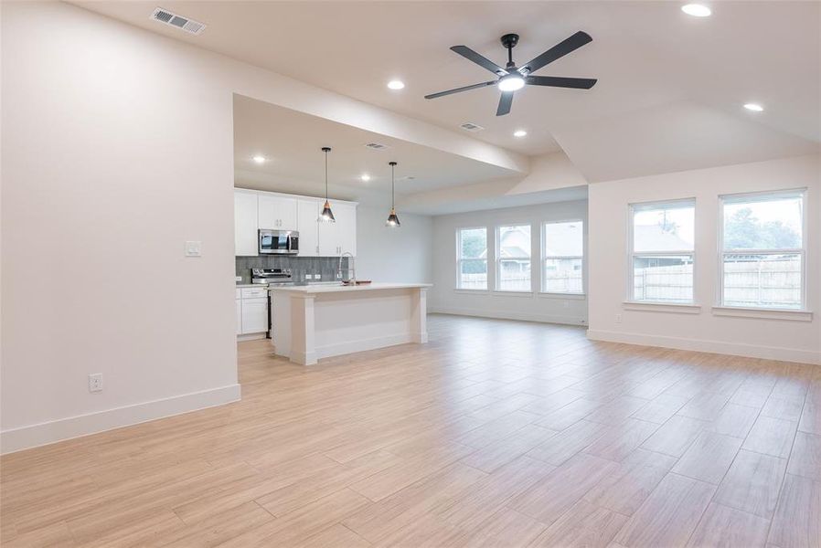 Unfurnished living room featuring light wood-style floors, recessed lighting, and ceiling fan