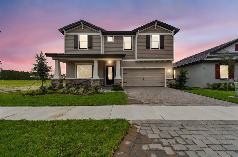 Front exterior of a new home in Tamarack at Two Rivers, Zephyrhills, FL, highlighting curb appeal (Image 2). Front exterior of a new home in Tamarack at Two Rivers, Zephyrhills, FL, highlighting curb appeal (Image 2).