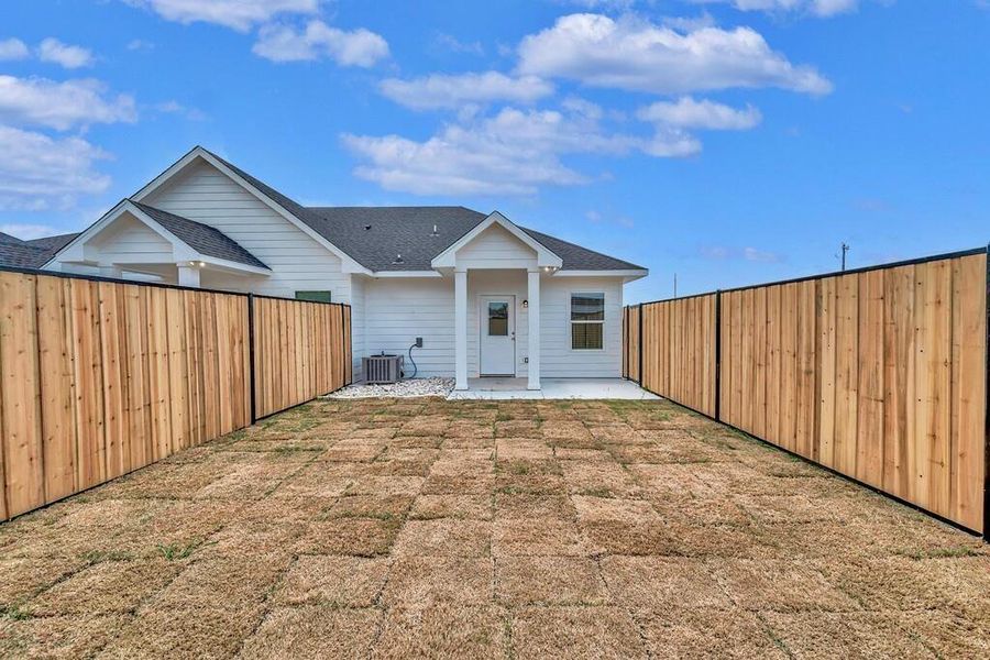 Back of house featuring a patio, a fenced backyard, and roof with shingles