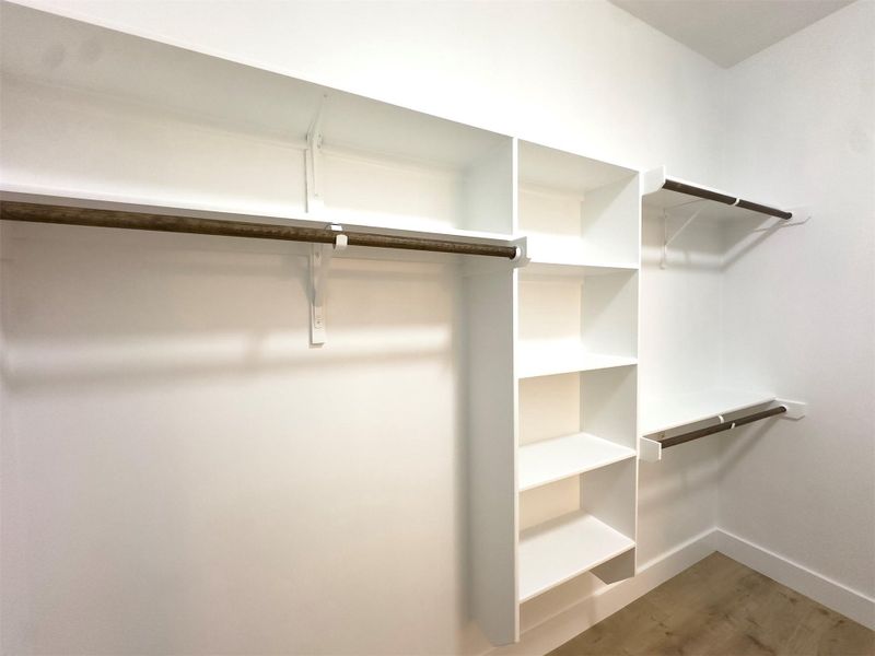 Generous built-in shelving and hanging rods maximize storage within this walk-in closet. Generous built-in shelving and hanging rods maximize storage within this walk-in closet.