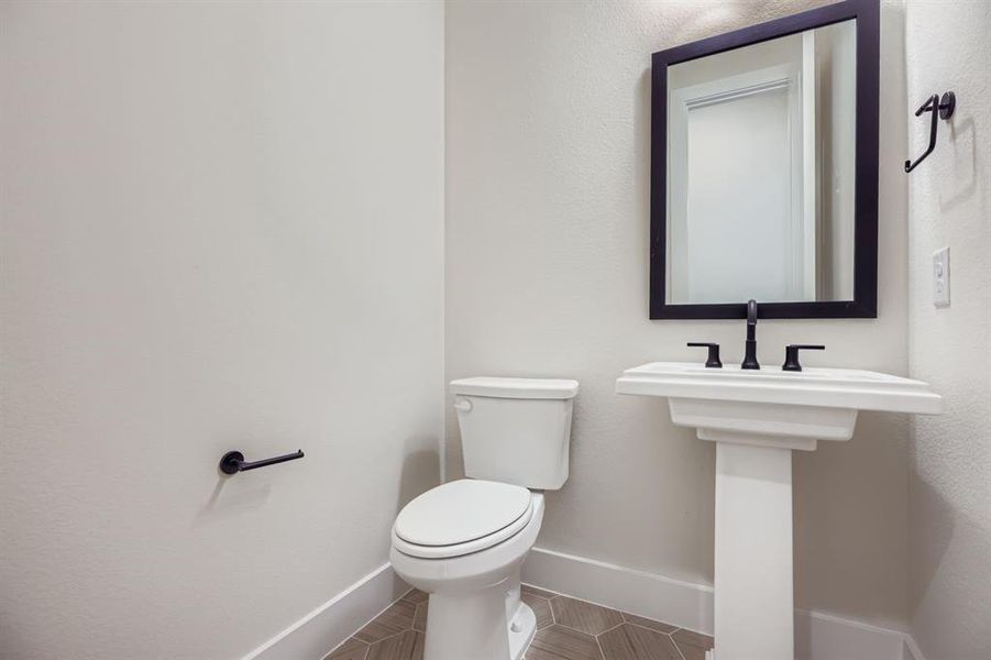 Bathroom featuring baseboards and toilet Bathroom featuring baseboards and toilet