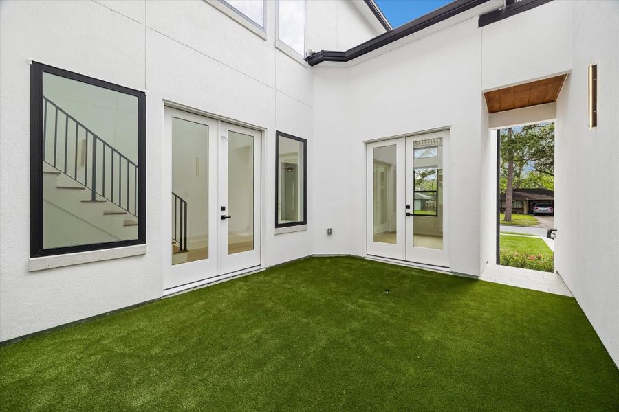 Doors to the left access the Entry hall and the others to the right go to the Study. The gated door to the right permits ingress from the driveway area.