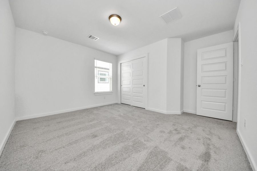 Generously sized secondary bedrooms featuring spacious closets, soft and inviting carpeting underfoot, large windows allowing plenty of natural light, and the added touch of privacy blinds for your personal retreat. Sample photo of completed home with similar floor plan. Actual colors and selections may vary.