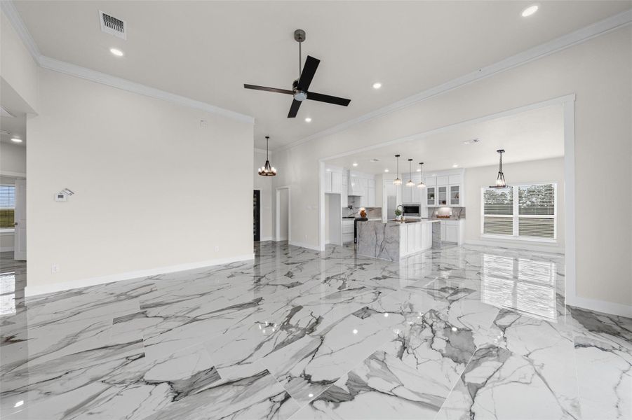 Gleaming polished tile floors guide the eye toward an inviting open-concept kitchen.