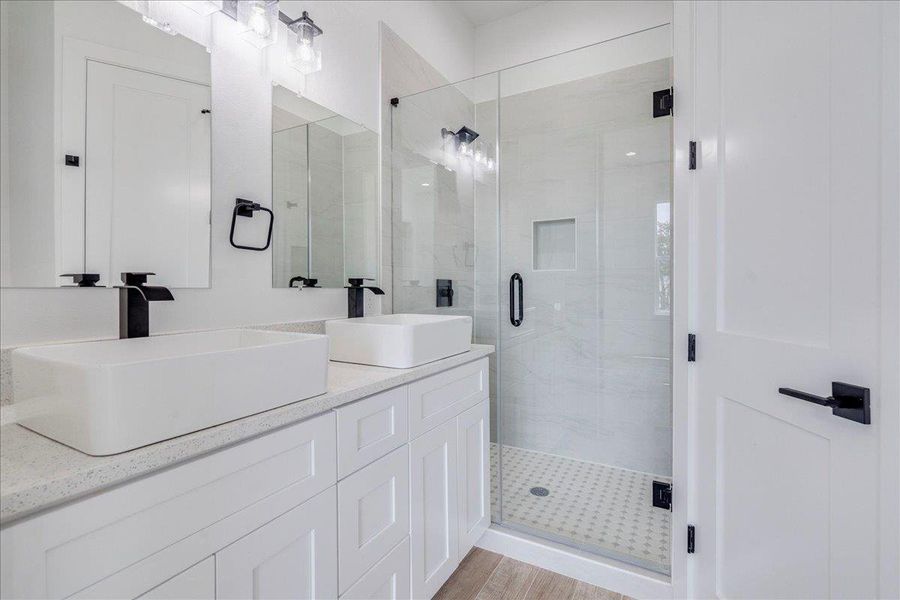 Primary bathrom on first floor with dual vanity and quartz counters