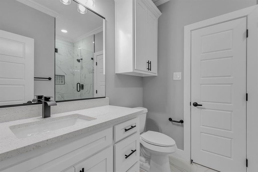 Bathroom with crown molding, toilet, vanity, and walk in shower