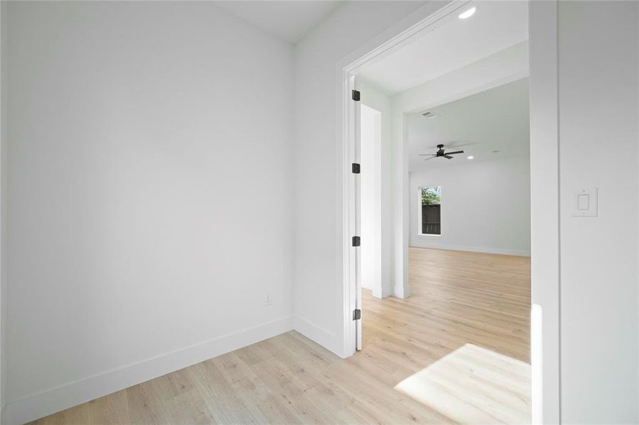 Corridor with light wood-style flooring and recessed lighting