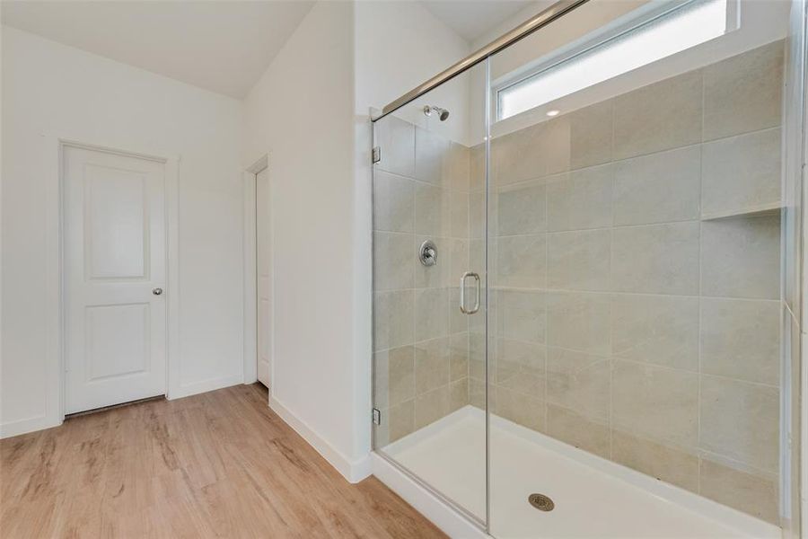 Bathroom featuring wood-type flooring and walk in shower