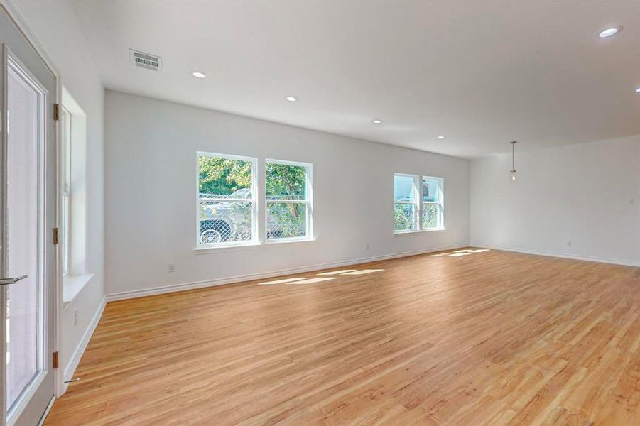 Spare room featuring light wood-type flooring and a wealth of natural light