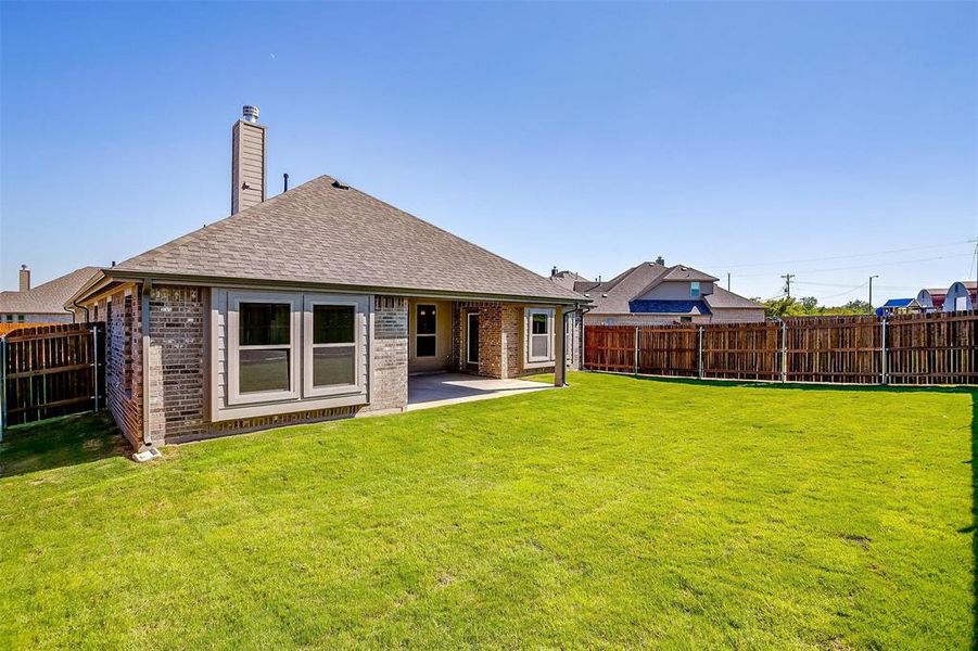 Back of property featuring a yard and a patio area