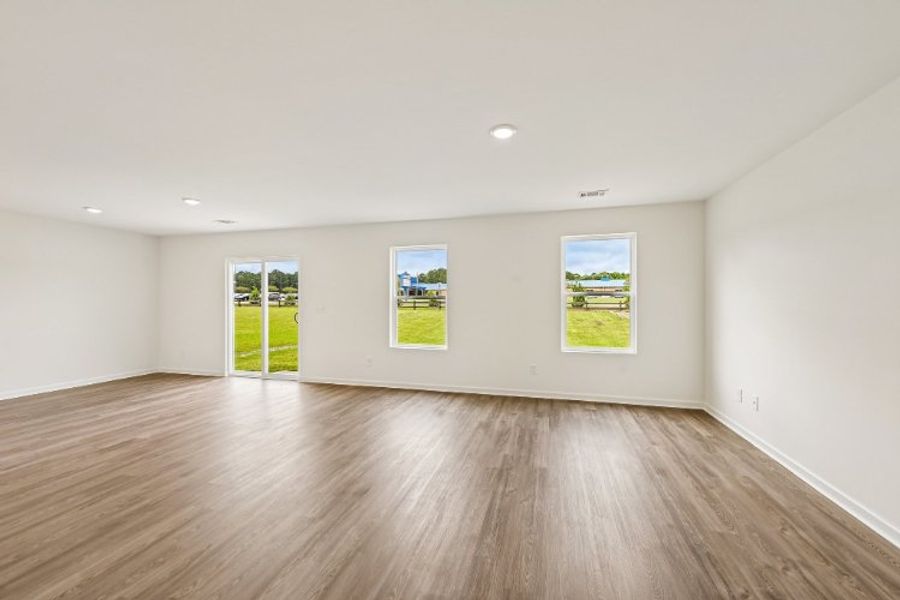 A room with a wood floor and a wood floor with a few paintings on the wall. A room with a wood floor and a wood floor with a few paintings on the wall.