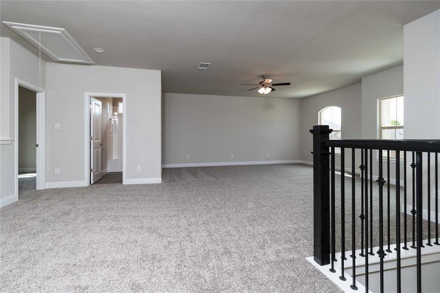 Carpeted spare room featuring ceiling fan