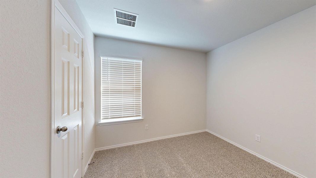An inviting room awaits with neutral walls and a window providing natural light.