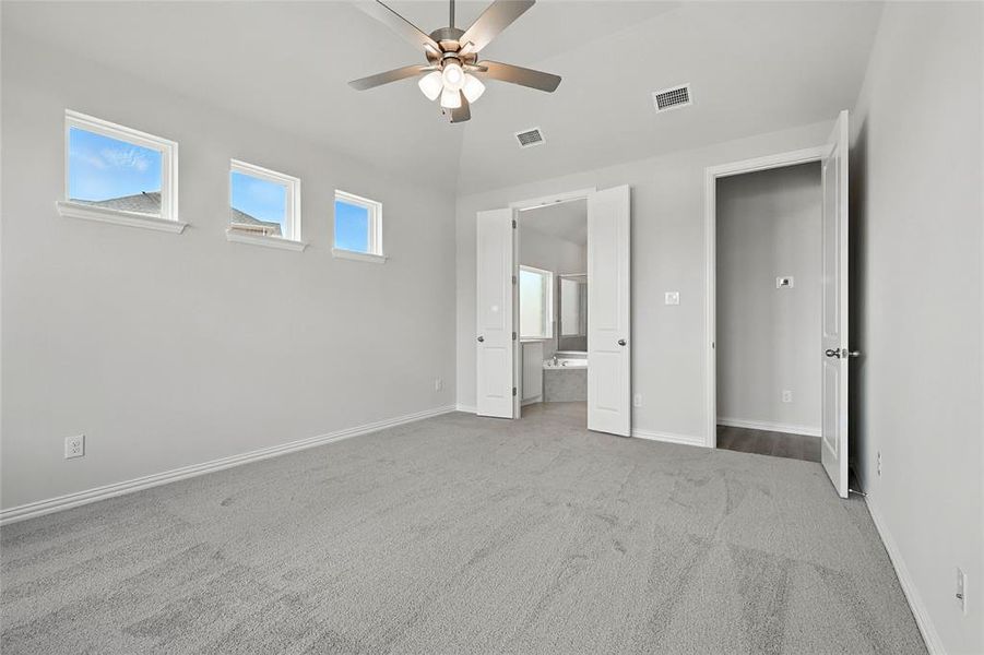 Unfurnished bedroom featuring carpet, ensuite bath, and a ceiling fan Unfurnished bedroom featuring carpet, ensuite bath, and a ceiling fan