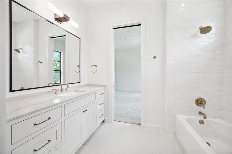 This bathroom offers a bright and clean aesthetic with its white vanity, and minimalist feel. The large mirror above the sink enhances the spacious feel, while the bathtub and shower area features sleek white subway tiles for a cohesive look. The simplicity of the design creates a serene and inviting space.