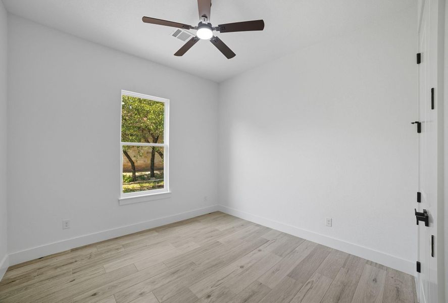 Spare room featuring light wood finished floors and a ceiling fan Spare room featuring light wood finished floors and a ceiling fan