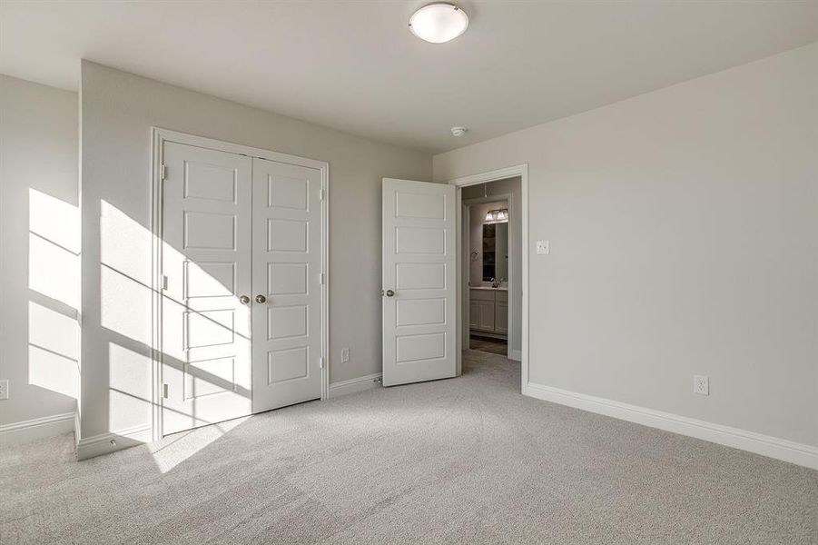 Unfurnished bedroom with light carpet and a closet