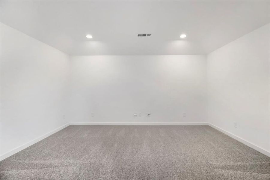 Spacious room featuring light gray carpeting, white walls, recessed ceiling lighting, and crisp baseboards Spacious room featuring light gray carpeting, white walls, recessed ceiling lighting, and crisp baseboards