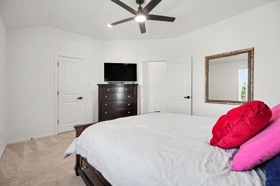 Secondary bedroom with vaulted ceilings, plush carpeting, and ample space for a variety of furniture arrangements. Secondary bedroom with vaulted ceilings, plush carpeting, and ample space for a variety of furniture arrangements.