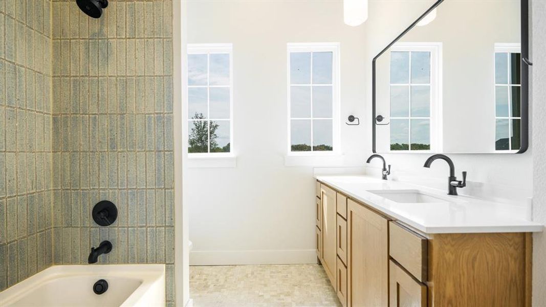 Bathroom with vanity, tile patterned floors, and a wealth of natural light