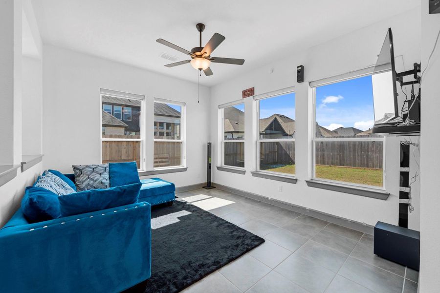 Sun-filled living area with expansive windows and backyard views, perfect for relaxing or entertaining.