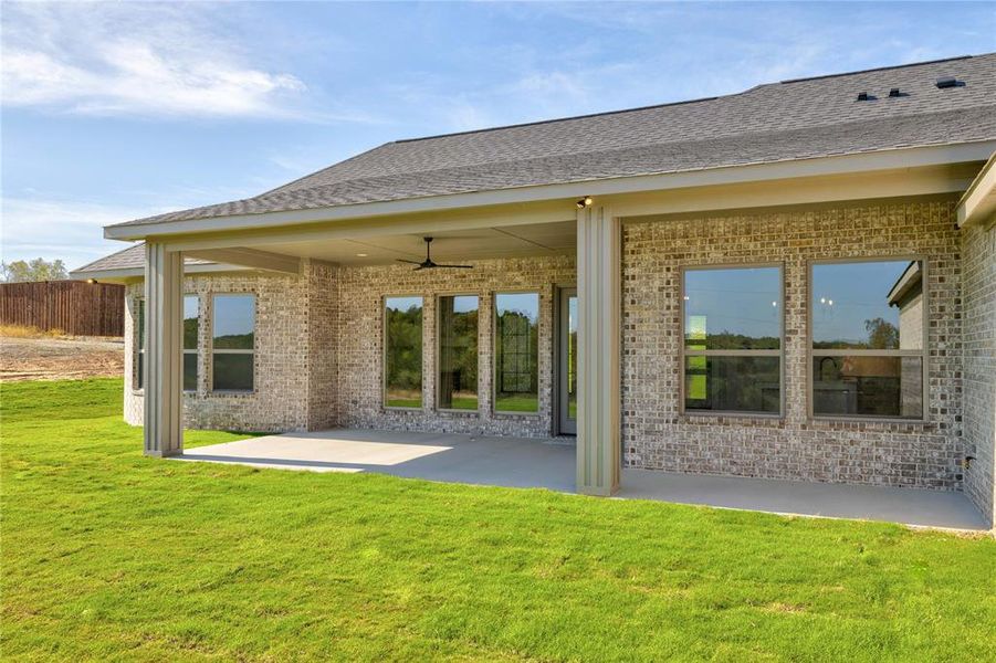 Rear view of house with a lawn, a patio area, and ceiling fan