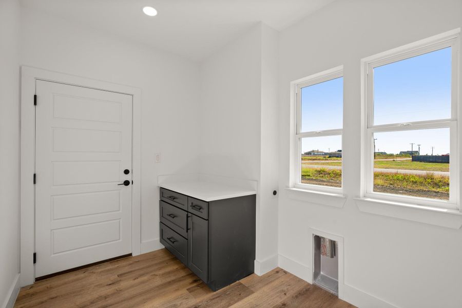 A dedicated laundry space offers functionality with ample counter space and natural light through two generous windows. A dedicated laundry space offers functionality with ample counter space and natural light through two generous windows.