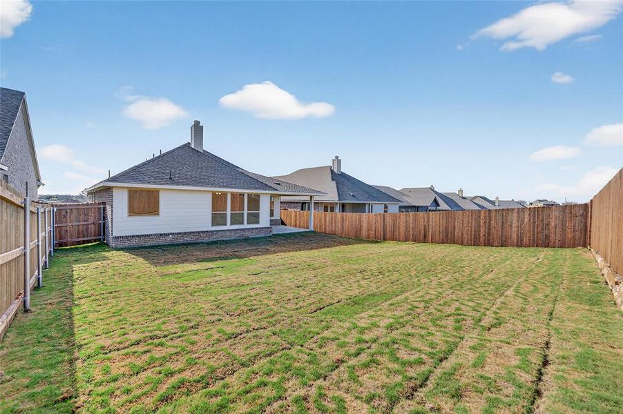 Rear view of house with a fenced backyard, a chimney, a patio area, and a shingled roof