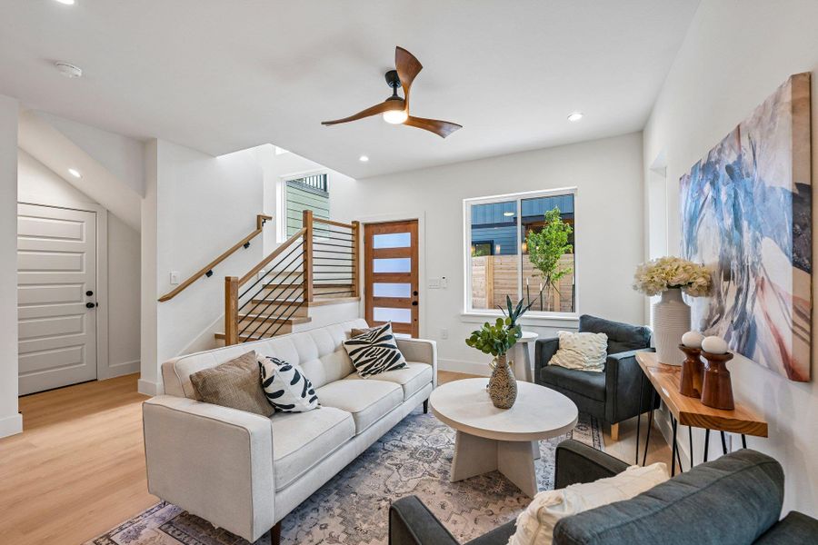 A contemporary living area showcasing a sleek staircase and abundant natural light. A contemporary living area showcasing a sleek staircase and abundant natural light.