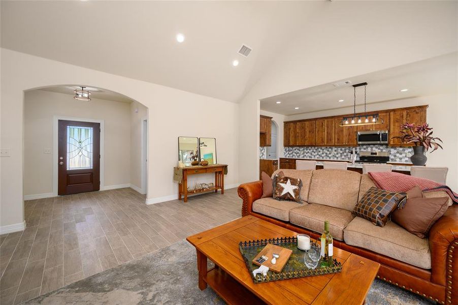 Living room featuring high vaulted ceiling and light wood-type flooring