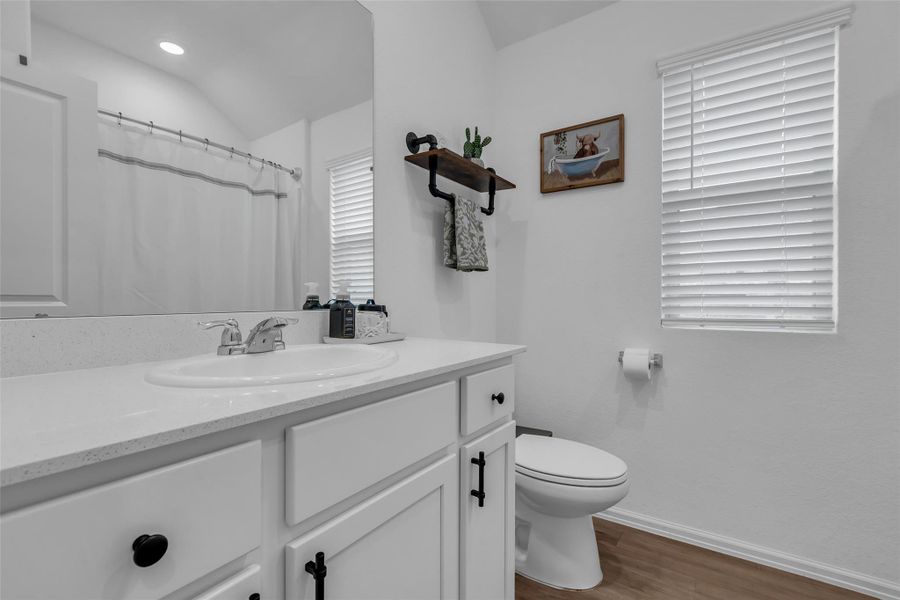 Here's a picture of the full bathroom located in between the two of the bedrooms. This bathroom has a bath/shower combination, sink, vanity space and toilet.