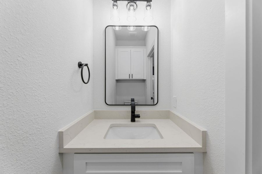 Modern vanity with ample counter space and sleek black fixtures.