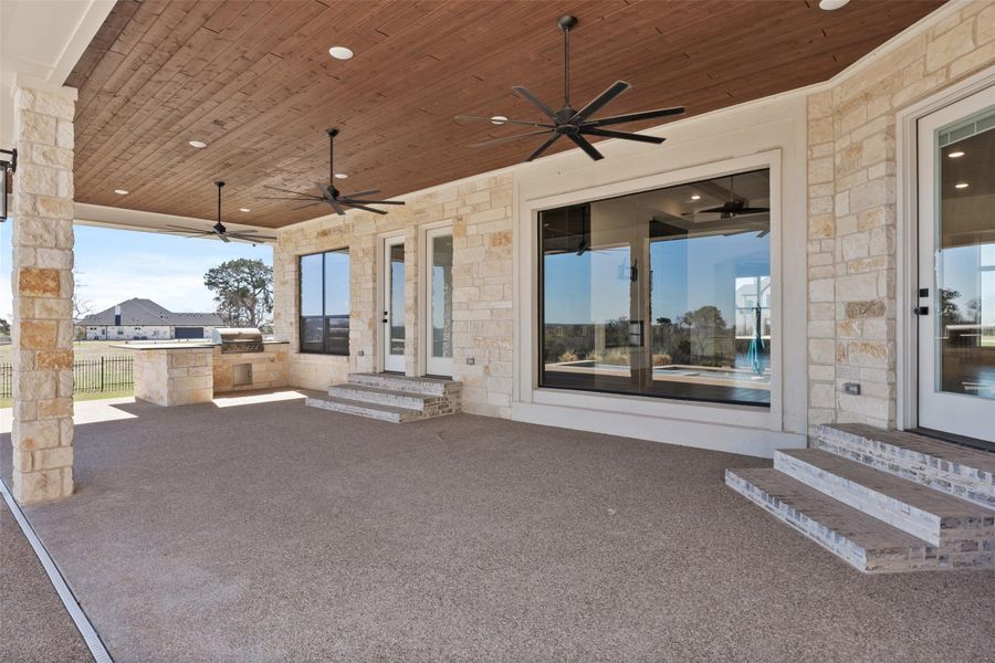 View of patio featuring entry steps, a grill, fence, and ceiling fan