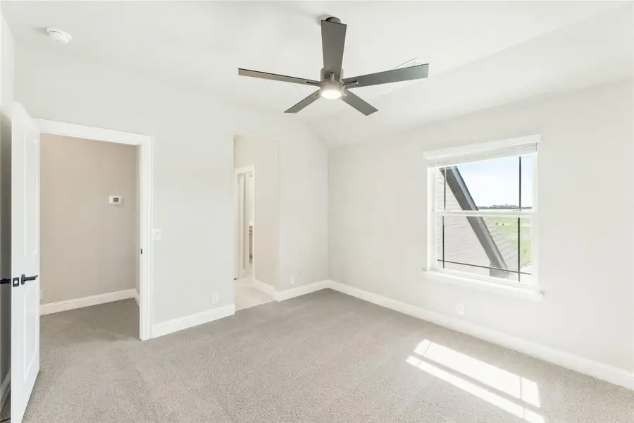 Empty bedroom with carpet flooring, ceiling fan, and window with natural light Empty bedroom with carpet flooring, ceiling fan, and window with natural light