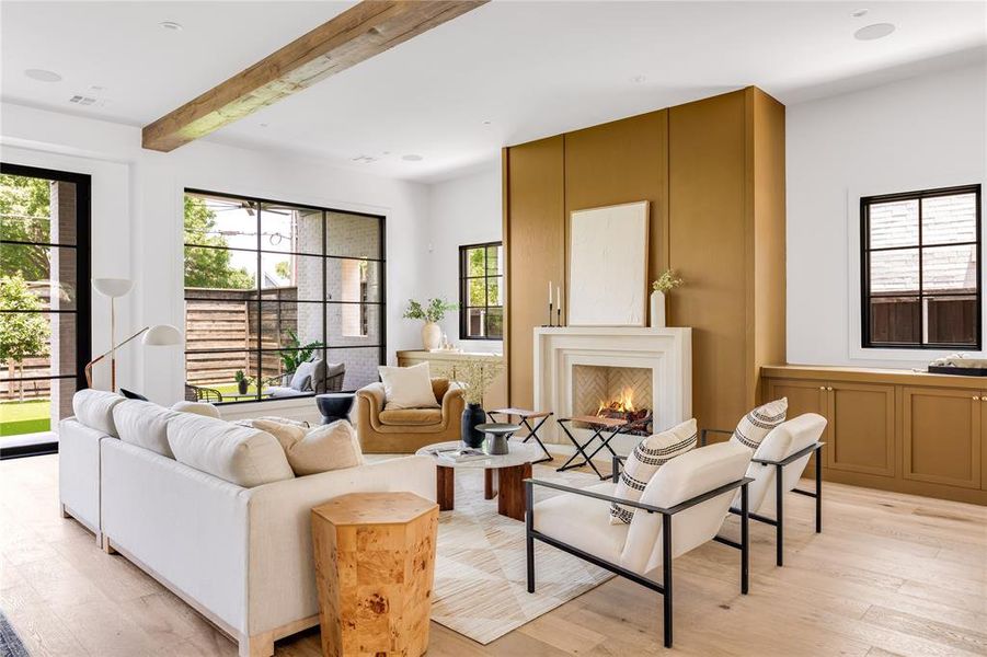 Living room with beamed ceiling and light wood-type flooring