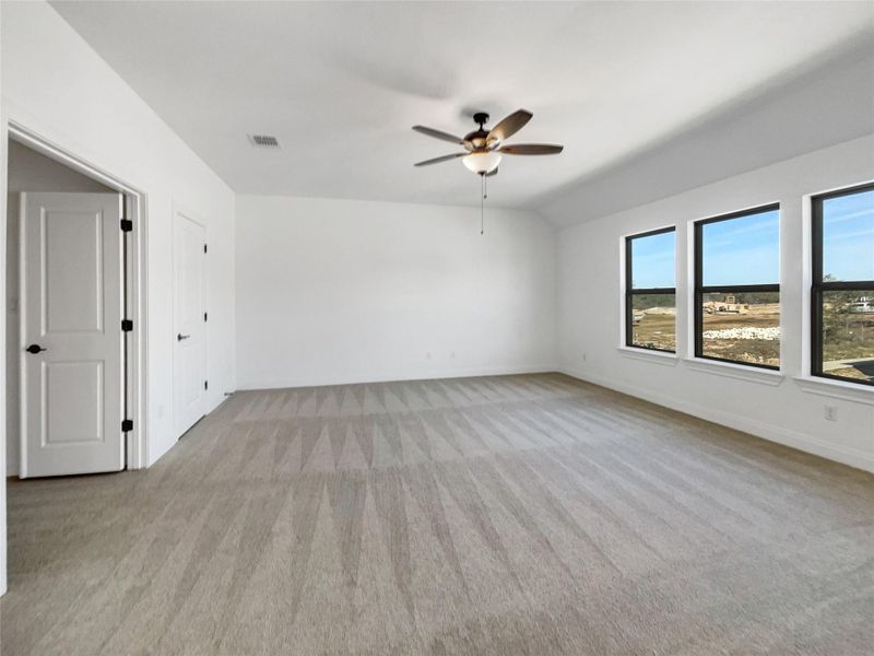 Spare room with visible vents, ceiling fan, baseboards, and lofted ceiling