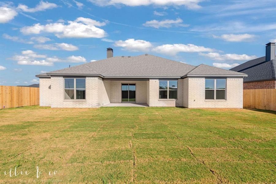 Rear view of property with a fenced backyard, a patio, brick siding, and a shingled roof
