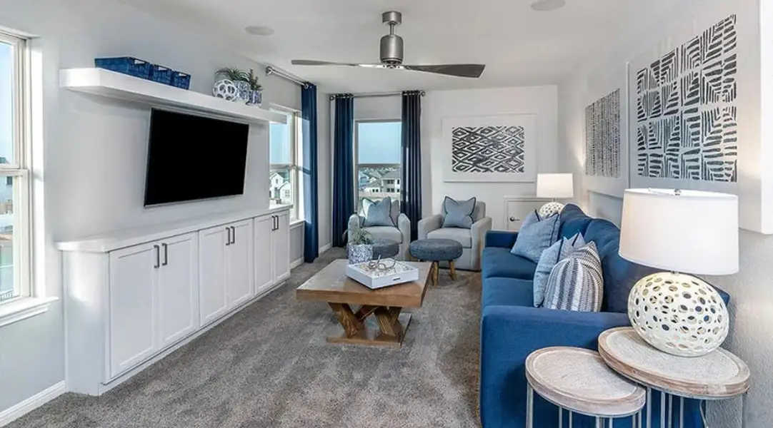 Living area featuring a ceiling fan and dark carpet