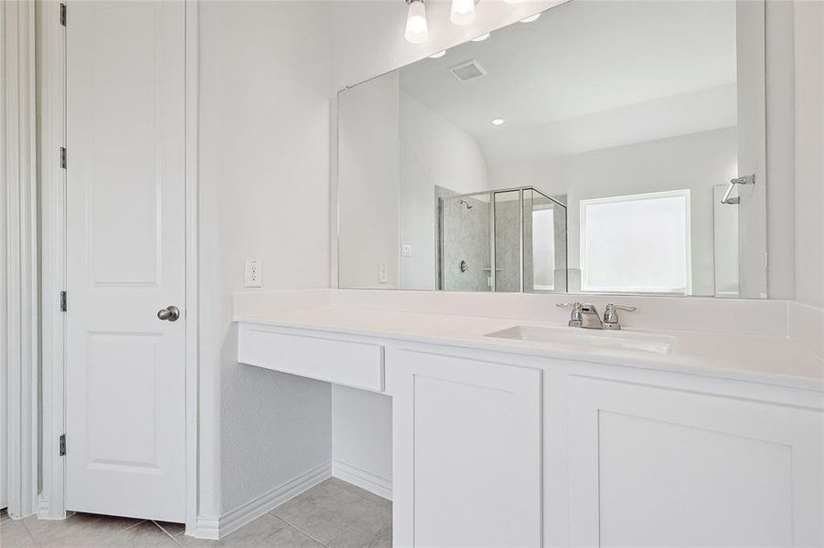 Bathroom with vanity, tile patterned floors, and walk in shower