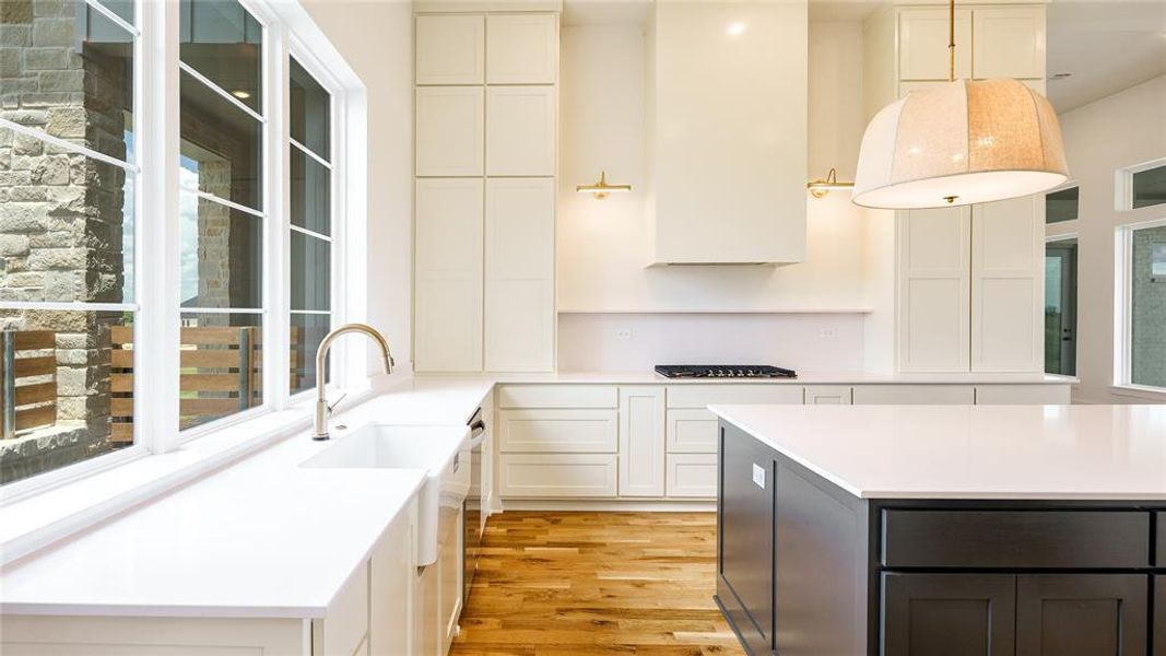 Kitchen with light hardwood / wood-style flooring, a kitchen island, and white cabinetry