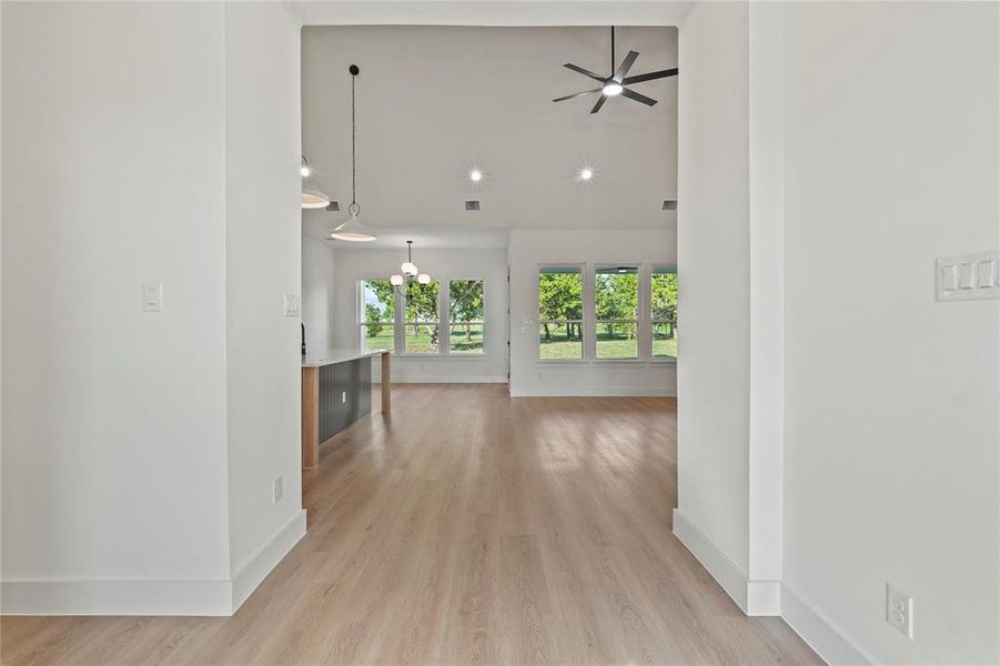 Corridor with high vaulted ceiling and light wood-type flooring Corridor with high vaulted ceiling and light wood-type flooring