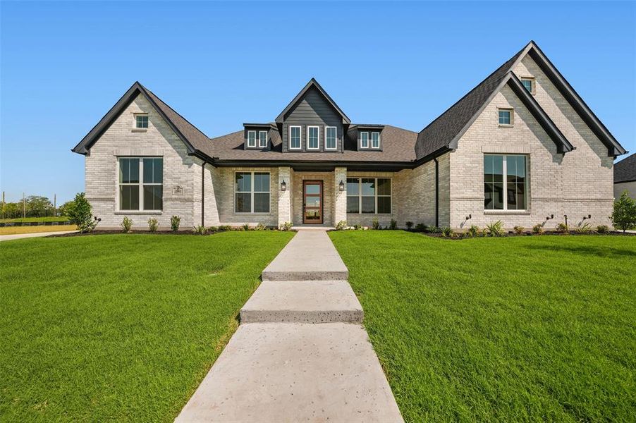 View of front of house featuring brick siding, a front yard, a porch, and a shingled roof