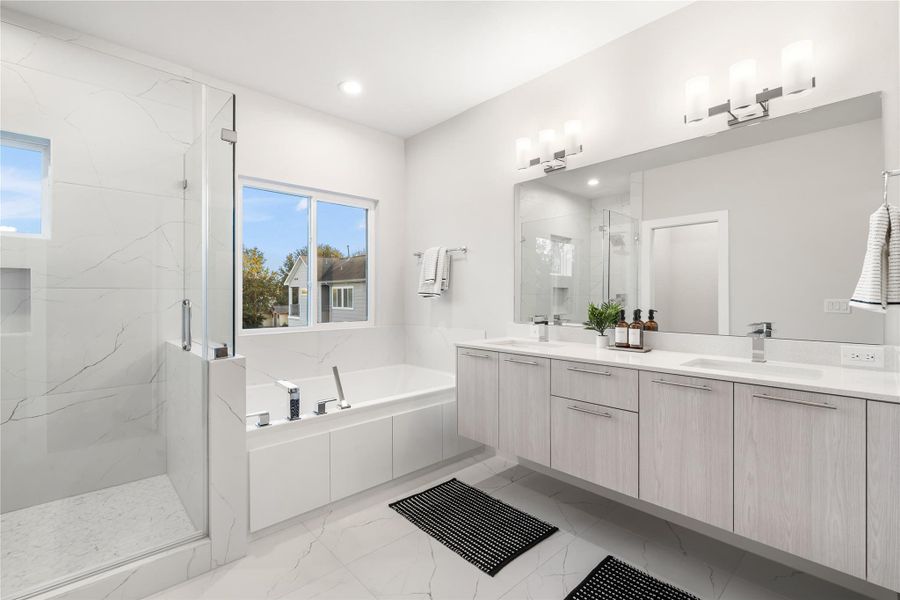 Dual floating vanities provide generous storage and are paired with a large framed mirror and sleek modern fixtures, creating a spa-like atmosphere you’ll love starting and ending your day in. Dual floating vanities provide generous storage and are paired with a large framed mirror and sleek modern fixtures, creating a spa-like atmosphere you’ll love starting and ending your day in.