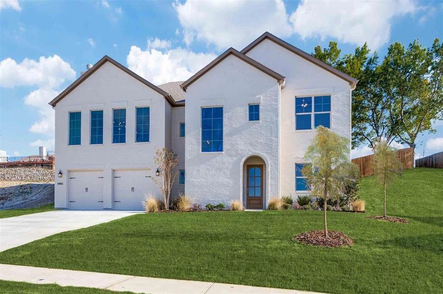 View of front facade featuring stucco siding, driveway, and an attached garage