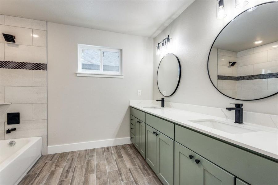 Bathroom featuring vanity, tiled shower / bath, and hardwood / wood-style flooring