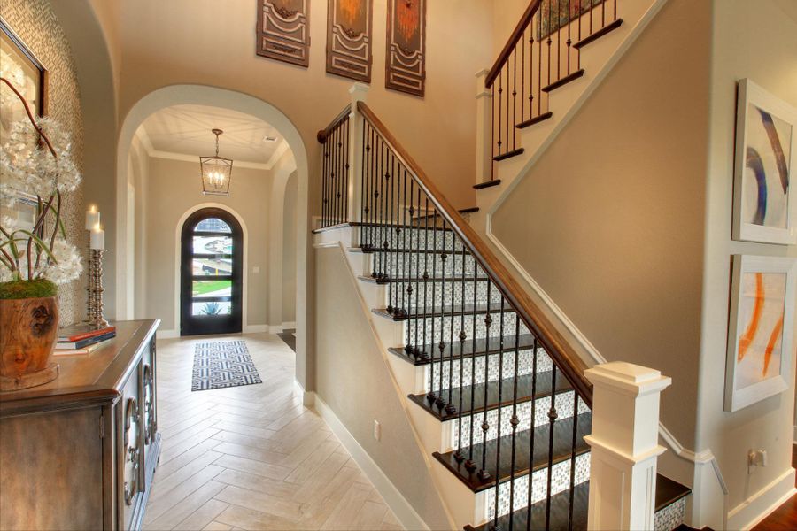 Entryway with a high ceiling, ornamental molding, arched walkways, and stairway Entryway with a high ceiling, ornamental molding, arched walkways, and stairway