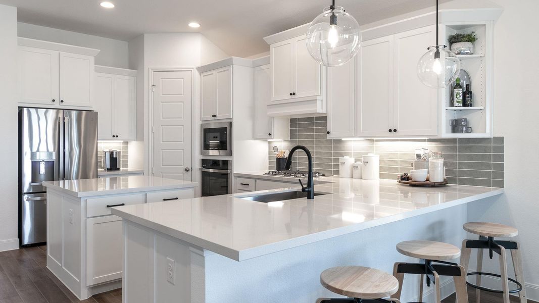 Kitchen featuring white cabinets, tasteful backsplash, a breakfast bar, decorative light fixtures, and a kitchen island