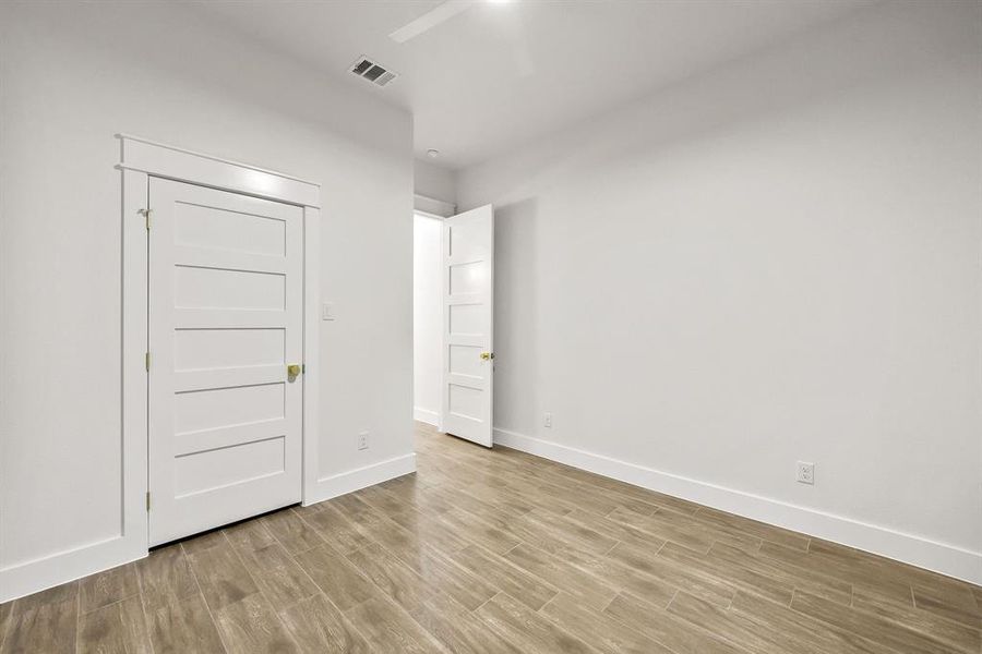 Light wood-finish flooring complements crisp white walls and baseboards